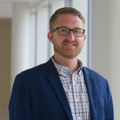 Headshot of Jeff Gruenewald in front of a window background.