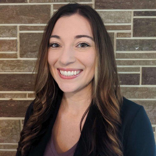 Headshot of Jessie Huff in frotn of a tiled background.