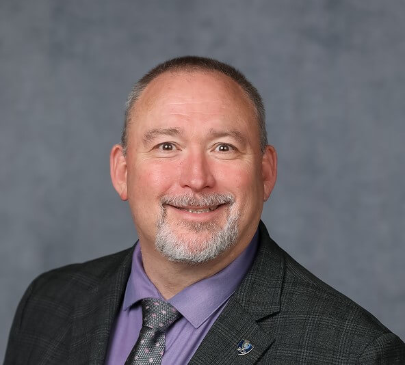 Headshot of Marshall Jones in front of a professional background.