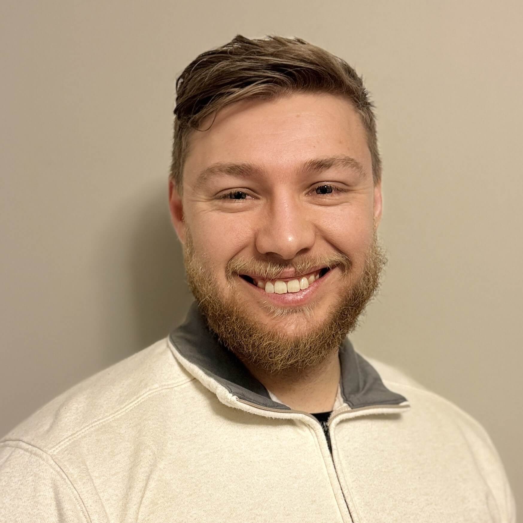 Headshot of Justin Lewis in front of a wall background.