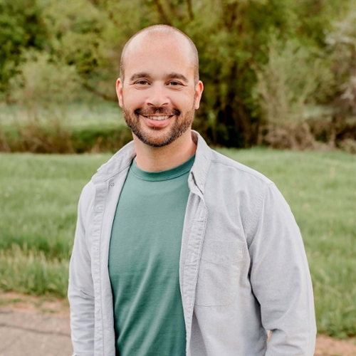 Headshot of Scott Mourtgos in front of a nature background.