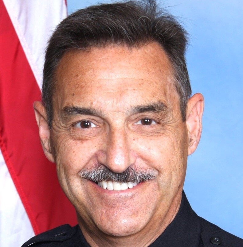 Headshot of Rick Myers in front of a professional background an An American Flag.
