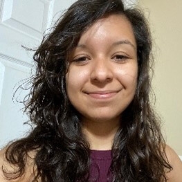 Headshot of Rosa Rivera in front of a door.