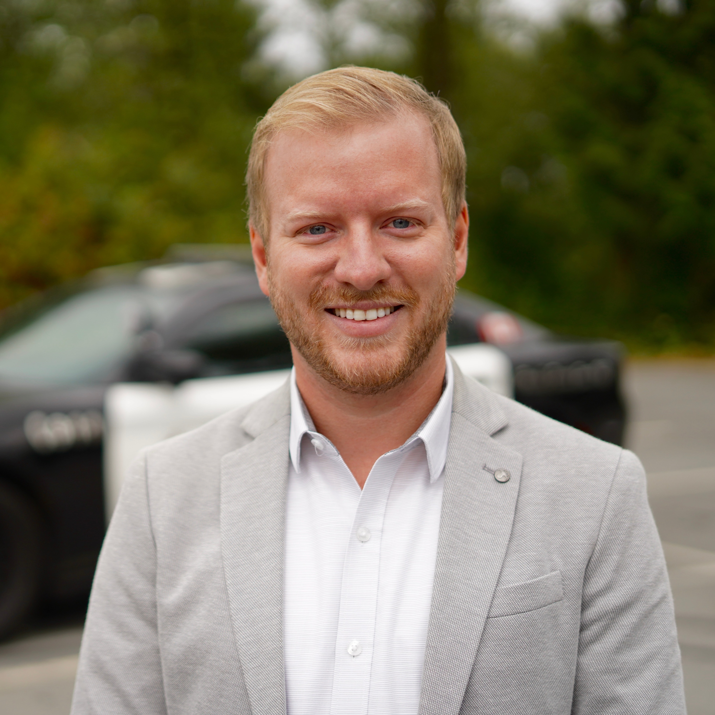 Headshot of Rylan Simpson in front of a police car.