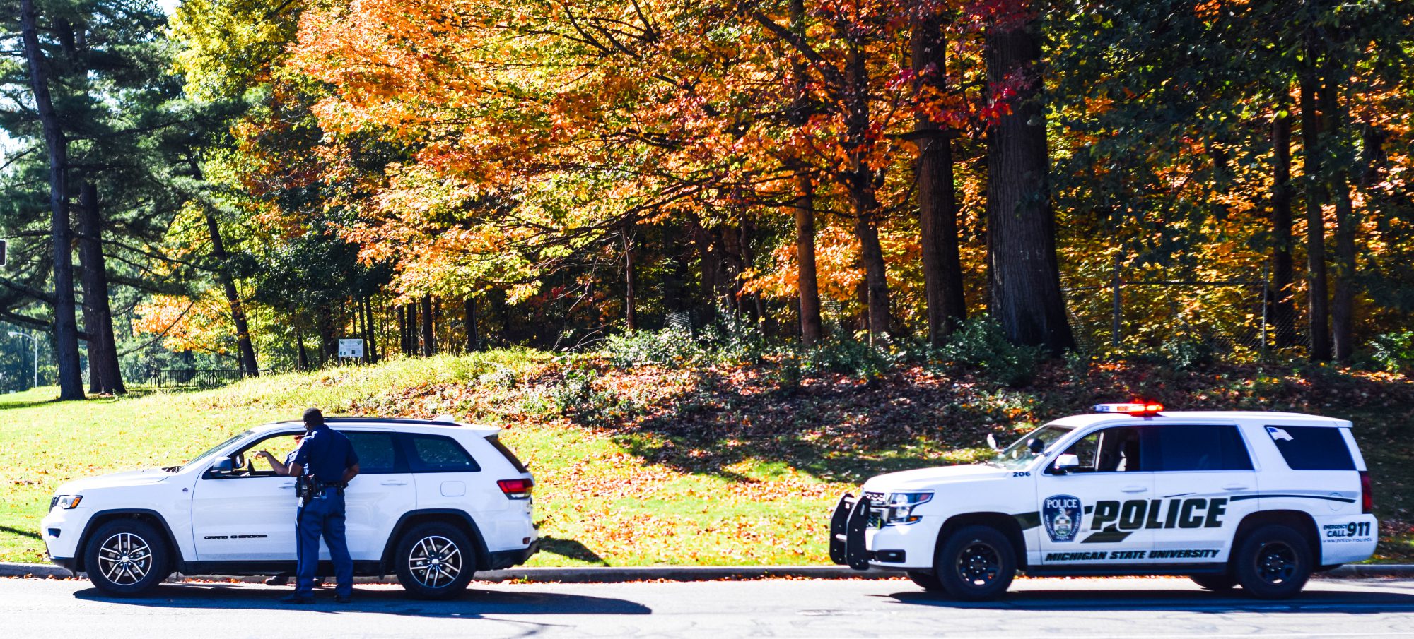 DPPS patrol vehicle making a traffic stop to white SUV in the fall