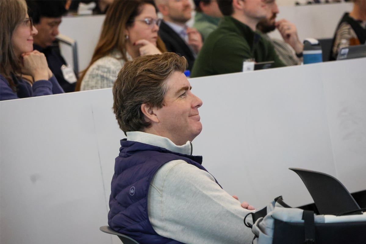 An AI Summit attendee smiling in the audience.