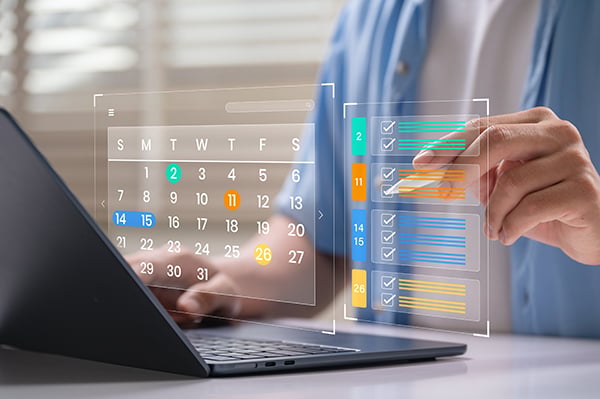A hand uses a stylus to select tasks on a calendar.