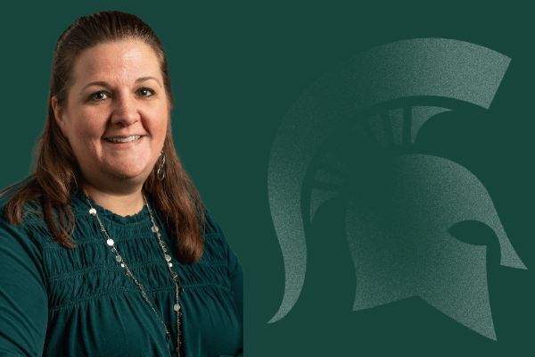 Shannon Kemp smiling, wearing a green blouse in front of a green background with a Spartan helmet logo.