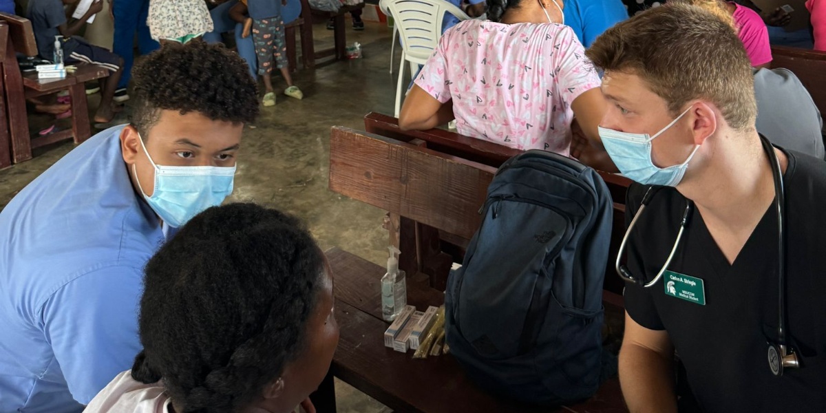 Two MSU medical students working with a patient
