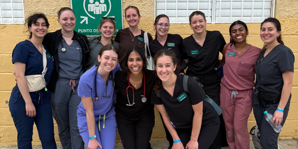 A group of MSU medical students taking a group picture in front of a medical clinic