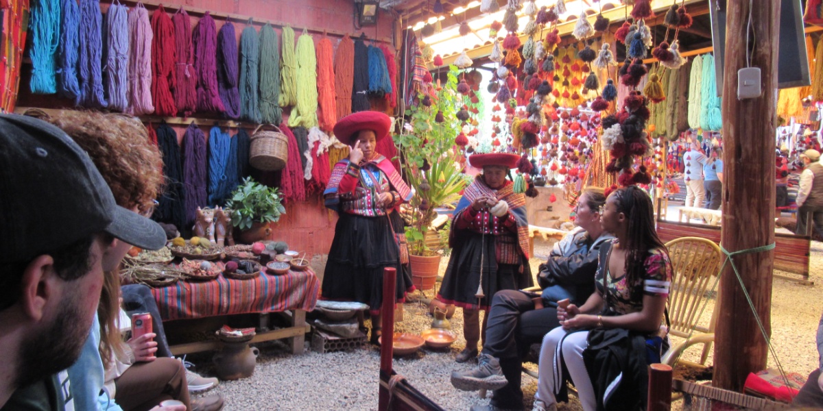 MSU students leaning about handmade yarn fabric threading from locals in Cusco, Peru.