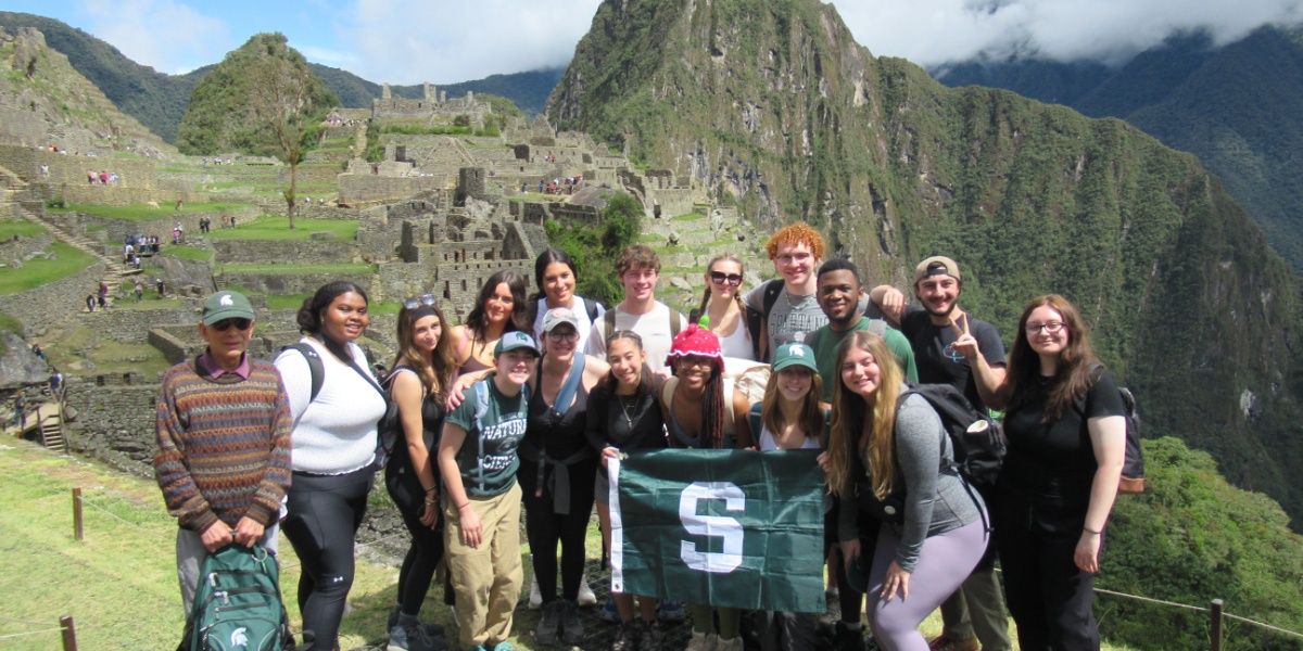 MSU students and faculty holding a Block S Michigan State flag at Machu Picchu