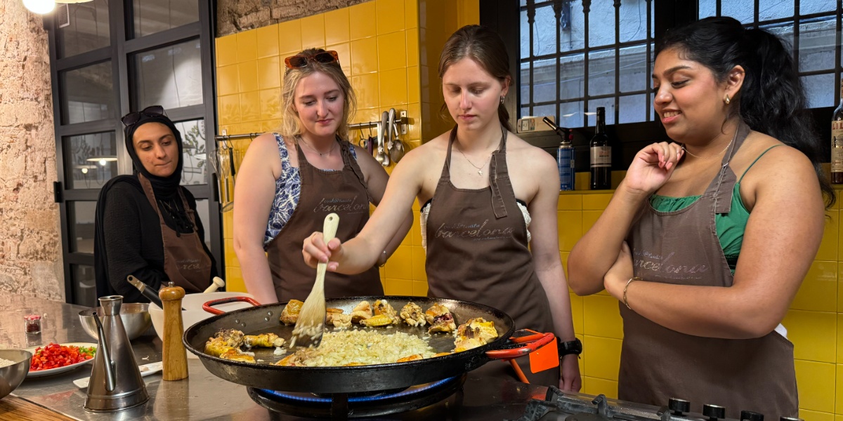 Four MSU students cooking Paella