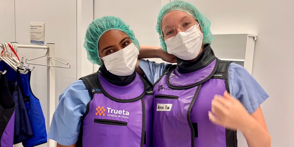 Two students wearing surgery protection gear inside a hospital