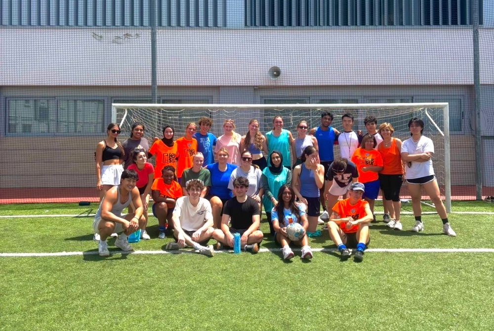 Manushree Ganta and her Spain pre-clinical observation cohort taking a group photo on a soccer field.