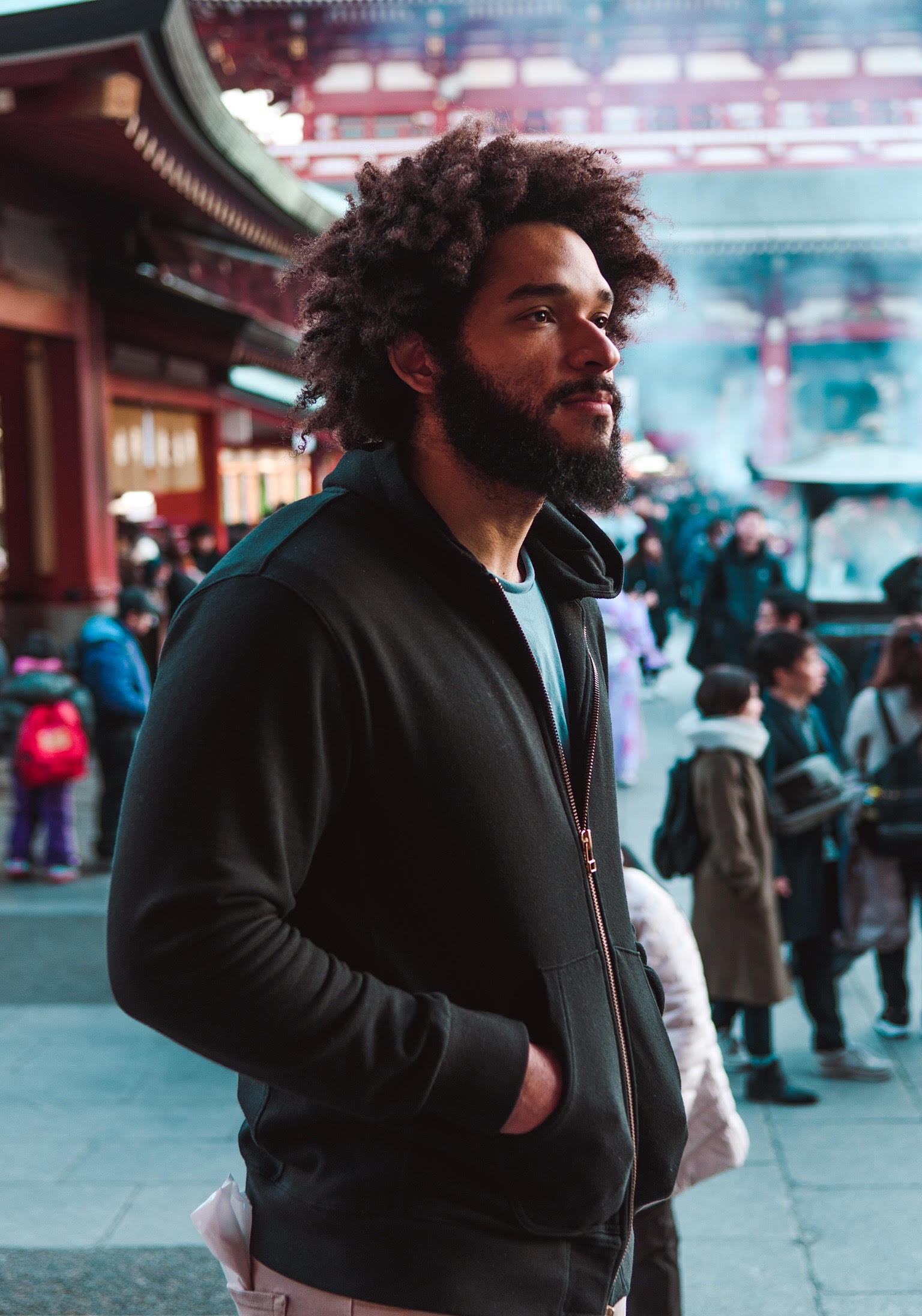 Carl Fields in a black hoodie, standing in a courtyard.