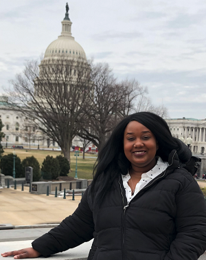 Jennifer Watts in a black suit, standing in front of the capital building.