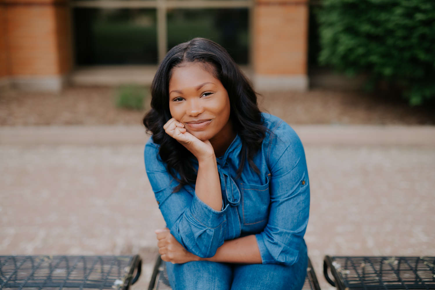 Antonia Gordon seated on a bench, wearing a blue jean jacket.