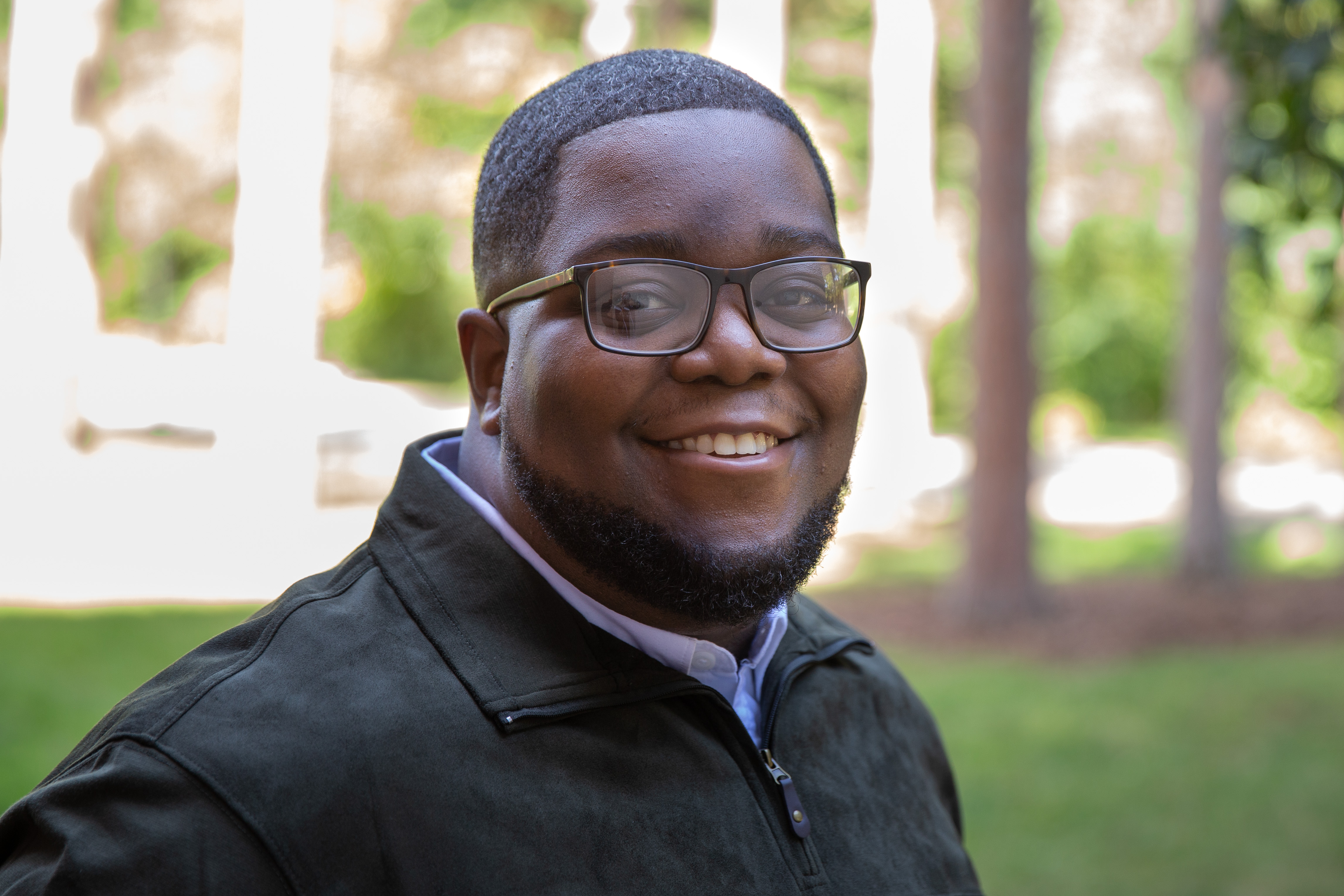 Johnathan Hill outdoors in a black zip-up jacket.