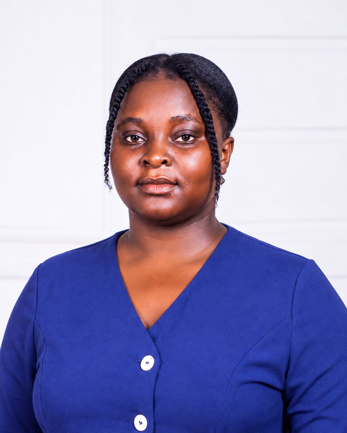 A woman in a royal blue blouse poses for a professional headshot against a light neutral background, looking directly at the camera with a calm expression.