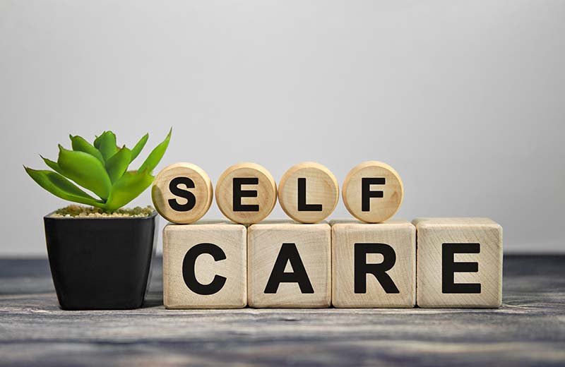 Wooden blocks on a table spell out "Self Care."