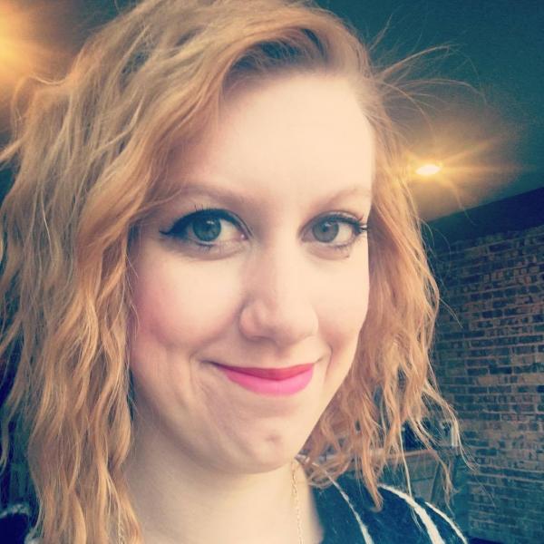 Heather Turner smiling for the camera in front of a brick wall.