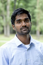 Vivek in a light blue shirt, standing outside.
