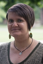 Karolina Achirri in a tan shirt and wearing earrings.