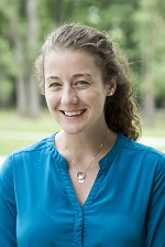 Mary Neville in a bright blue shirt, standing outside.