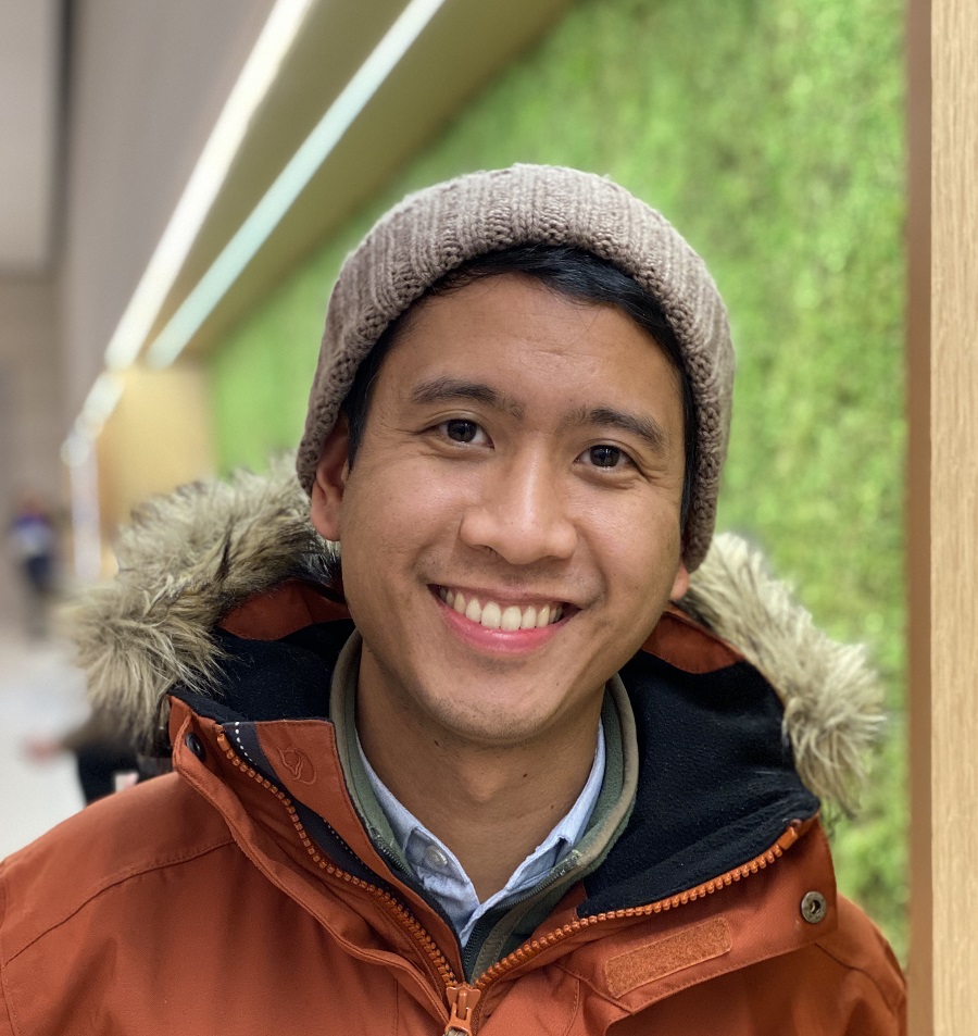 Lee Melvin Peralta in an orange jacket, standing in a hallway.