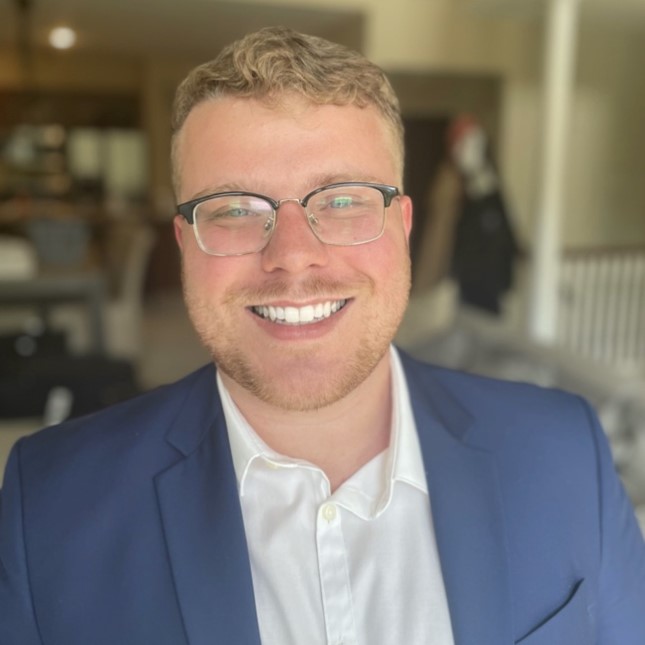 Graham Gardner in a blue suit coat and white undershirt.