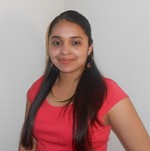 Patricia Jaimes standing in front of a wall while wearing a pink t shirt.