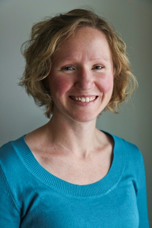 Sarah Evans smiling while wearing a blue sweater.