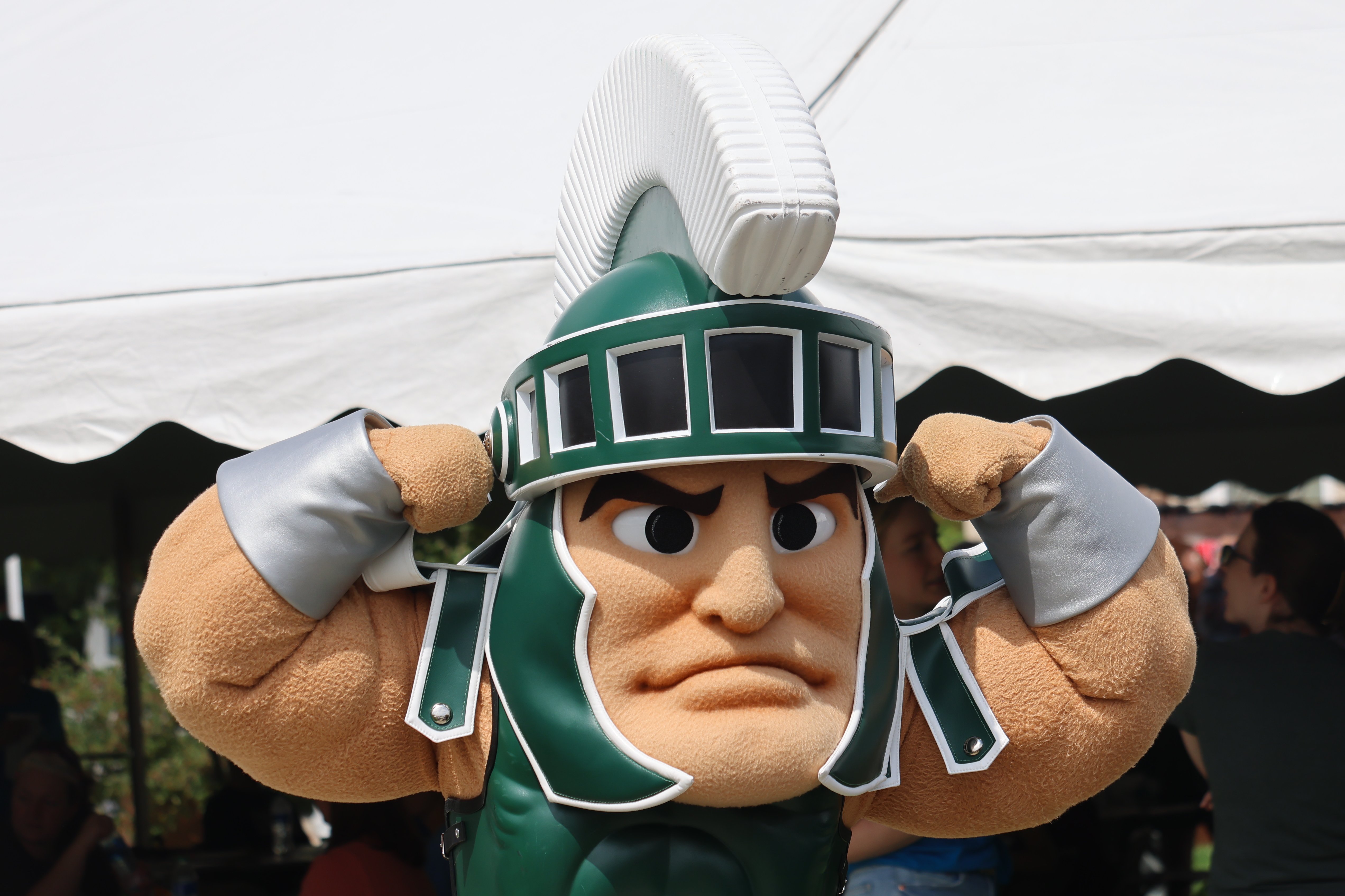 Sparty standing outside and flexing.
