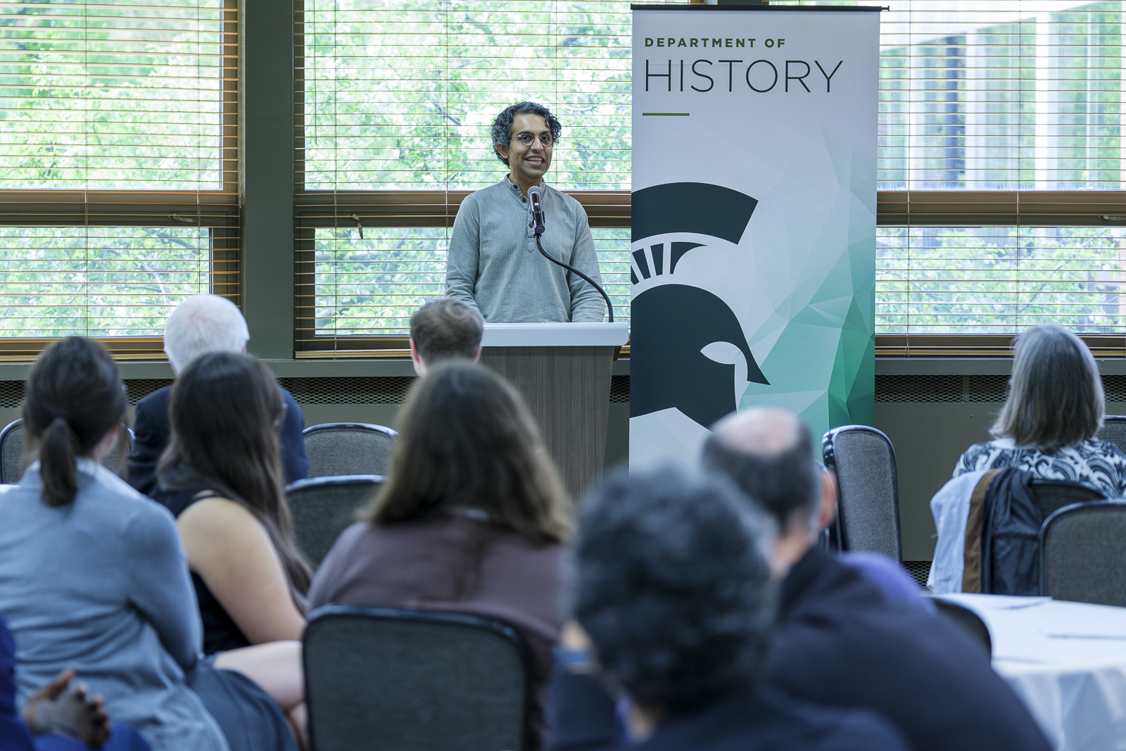 Assistant Professor Shayan Rajani speaks at the podium during the Department of History's 2026 awards ceremony.