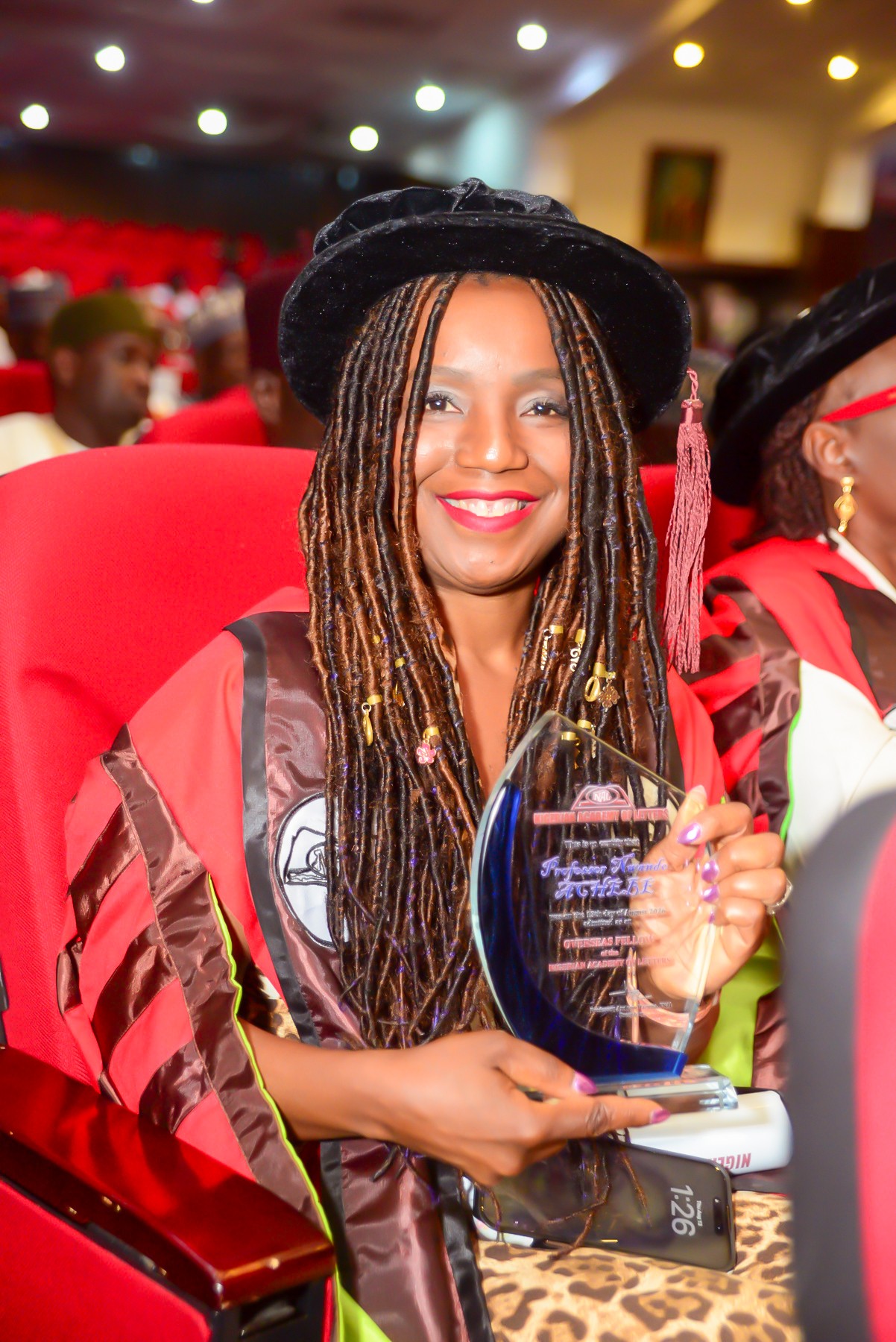 Nwando Achebe holding an award during her investiture with the Nigerian Academy of Letters