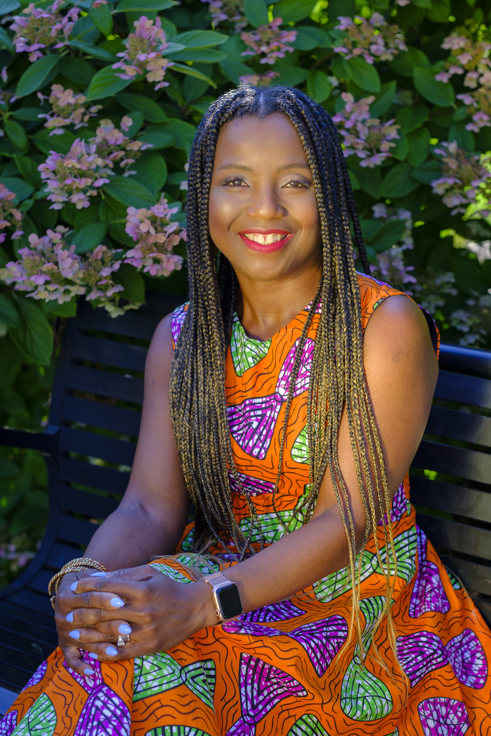 Nwando_Achebe poses for a photo while sitting on a bench.