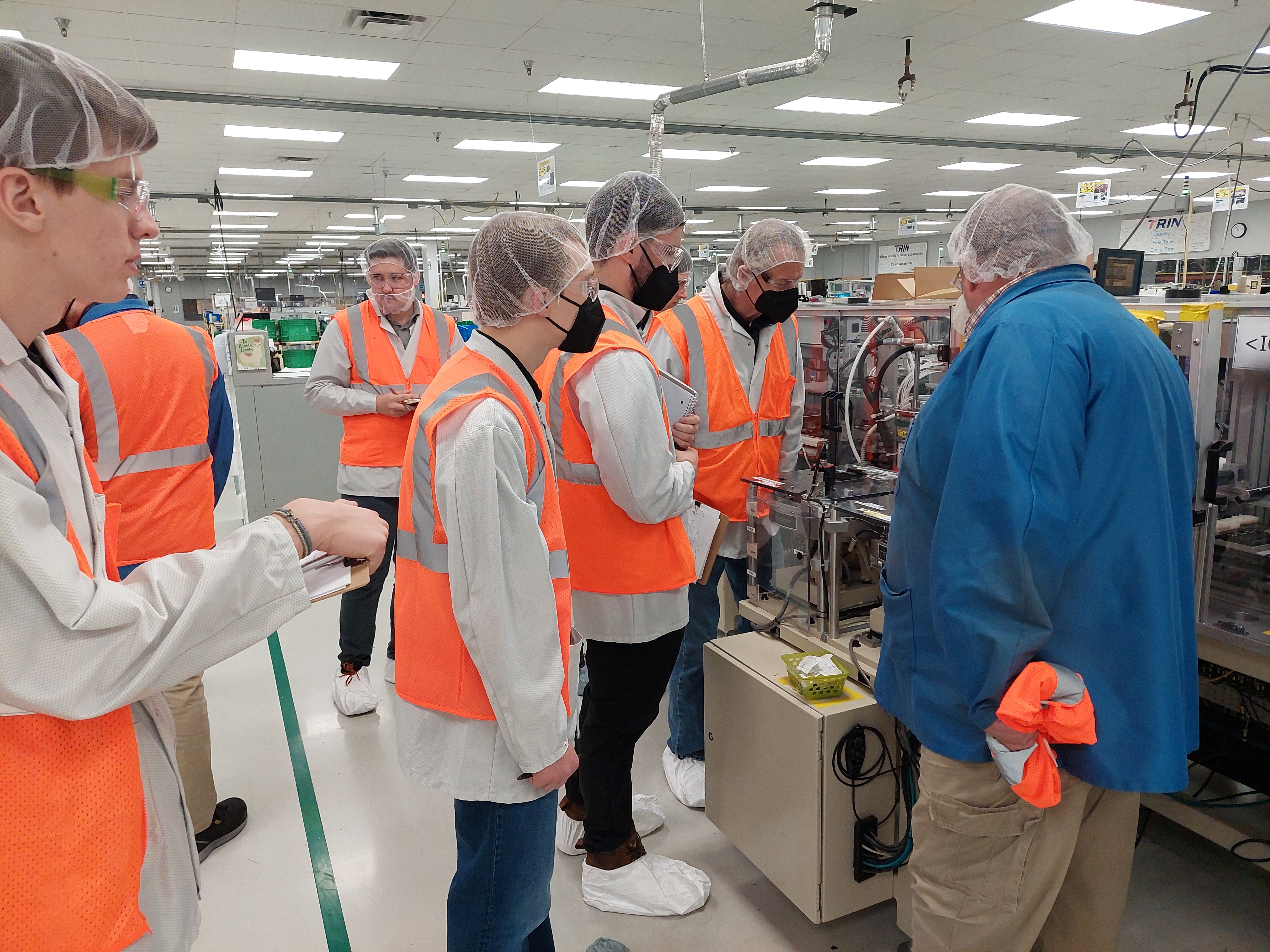 Students and facility personnel with machine