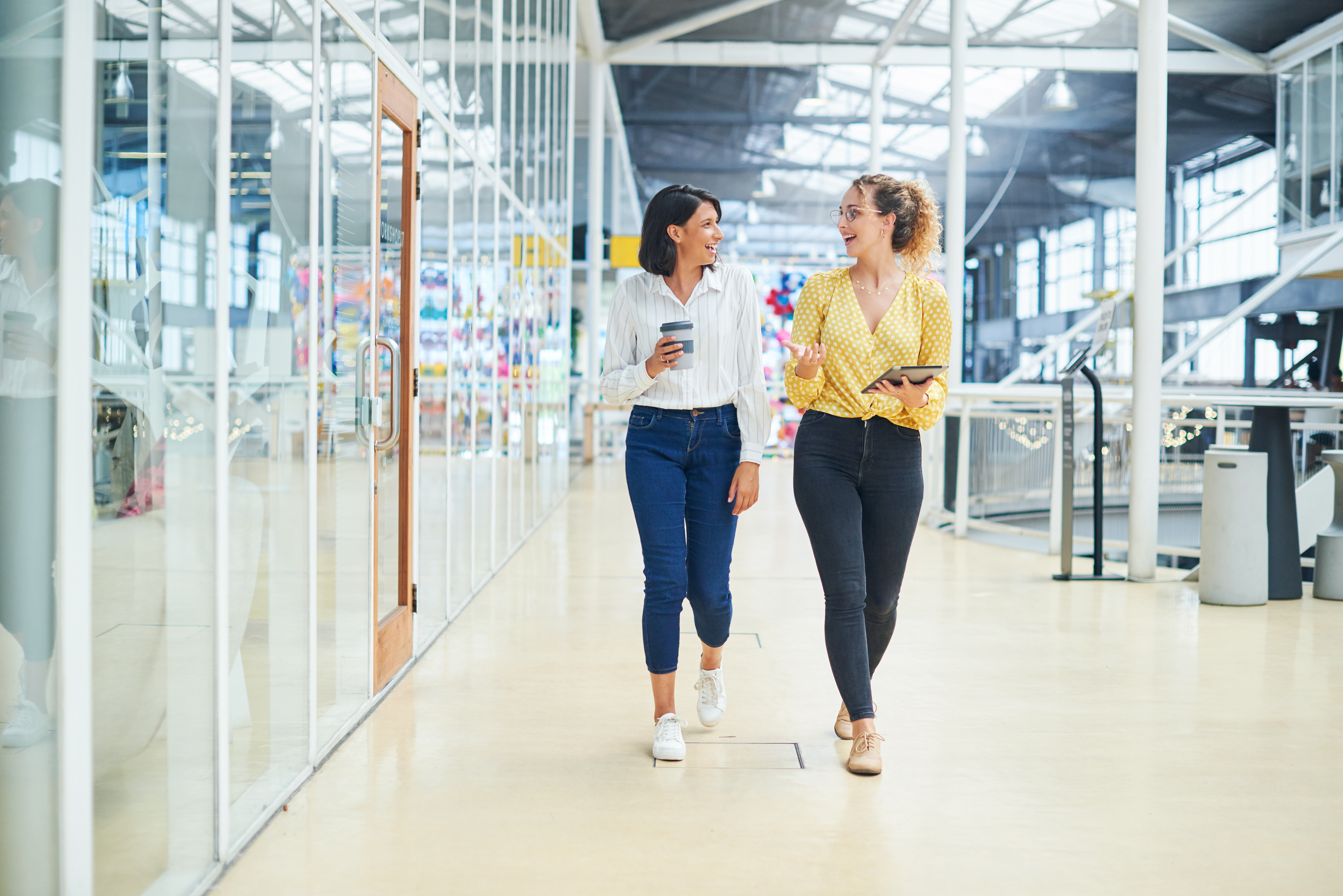 Two women walking down a hallway in an engineering lab.