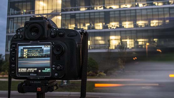 A photo of a camera taking a photo of the 1855 Place building. 