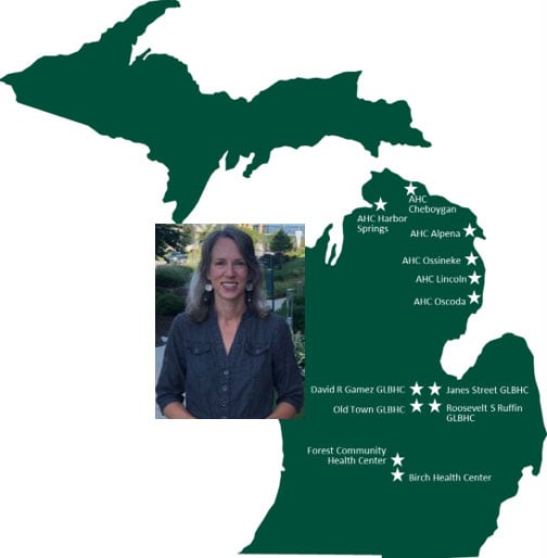 This image depicts a map of Michigan set against a white background, shaded in Spartan green. Across the map, several star symbols are distributed, marking various clinic locations. The clinics indicated include AHC Harbor Springs, AHC Cheboygan, AHC Alpena, AHC Ossineke, AHC Lincoln, AHC Oscoda, David R Games GLBHC, Old Town GLBHC, Janes Street GLBHC, Roosevelt S Ruffin GLBHC, Forest Community Health Center, and Birch Health Center. Each star symbol is shaded in white, of the same size, and serves to denote a distinct clinic location within the state.  Image of Amy Seaver on top left.