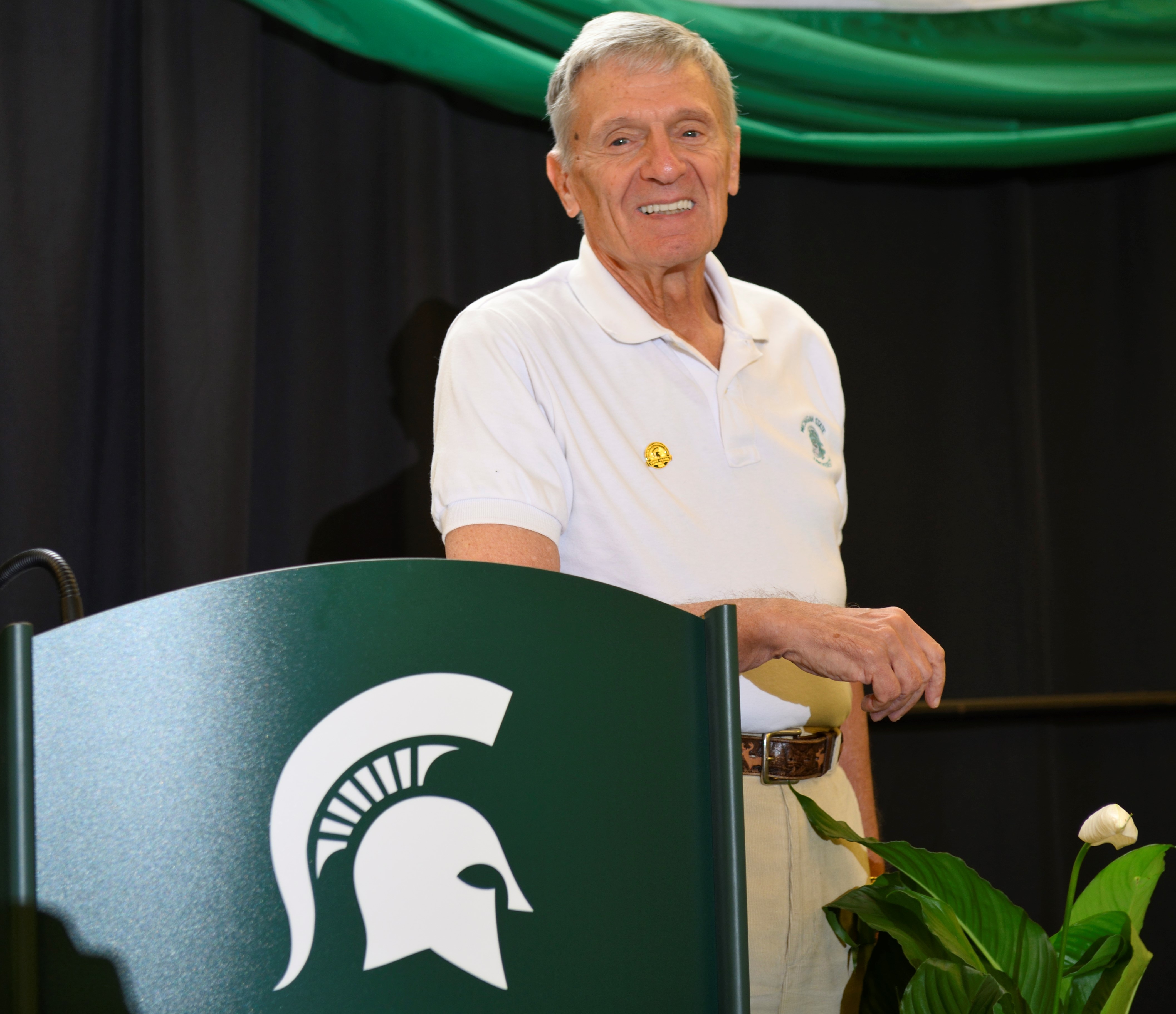Photo of Jack Katosh in a white Spartan shirt behind a spartan podium