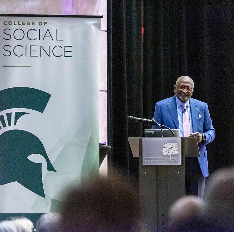 A photo of Dr. Robert Bullard speaking on stage behind a podium