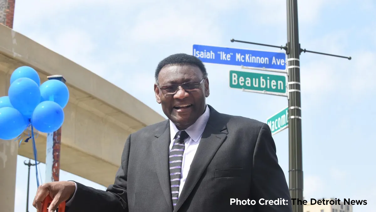 A photo of Ike McKinnon by two street signs that read Isaiah Ike McKinnon Ave and Beaubian with text on the photo that reads Photo Credit Detroit Free Press