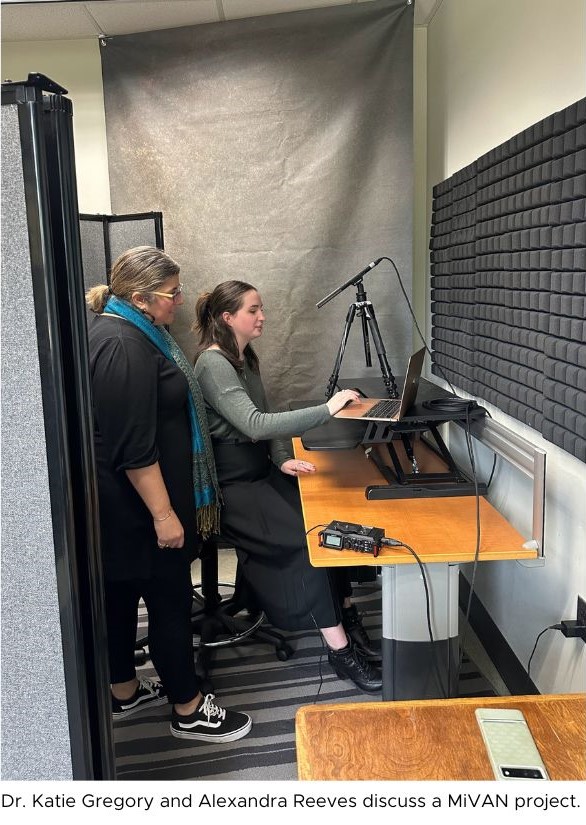 Two women work on recording audio in a studio in front of a microphone