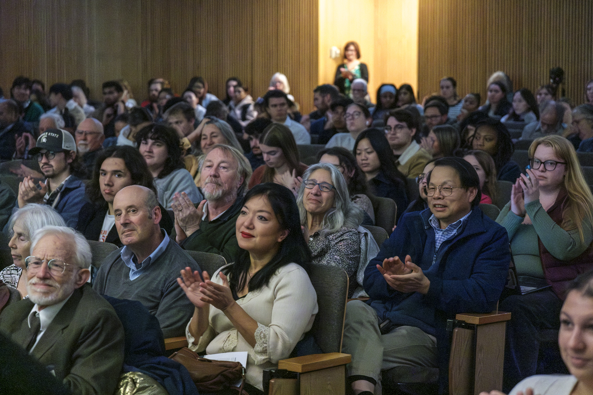 People clapping, listening to a presentation
