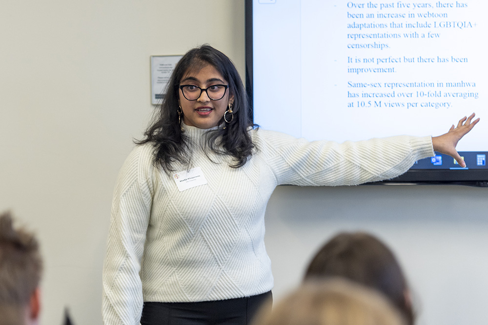 A student presents research in front of a group of people