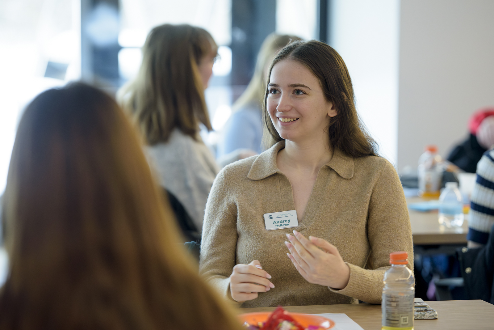 Women chat around a table.
