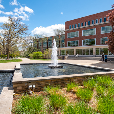 The outside of Michigan State University's Main Library with a fountain and plants.