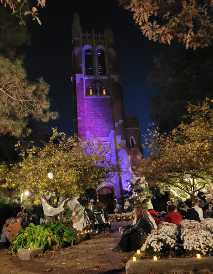 MSU Beaumont Tower at night with purple spot light and spooky campus decorations